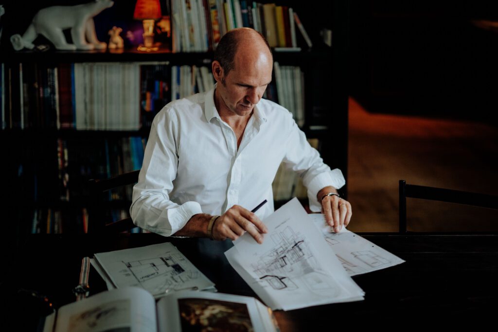 Portrait of Tristan Auer in his Montmartre home Portrait of French interior designer Tristan Auer working in his Montmartre studio room, surrounded by curated vintage furniture and natural light.