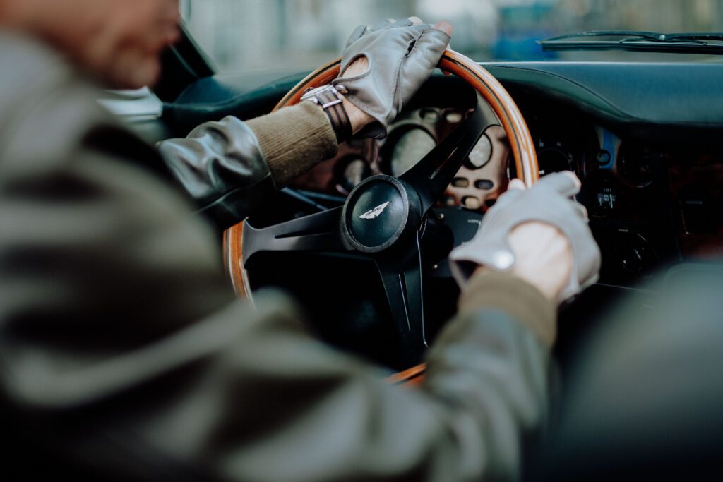 Interior view of Tristan Auer’s vintage Aston Martin as he drives through central Paris, captured during a candid lifestyle shoot.