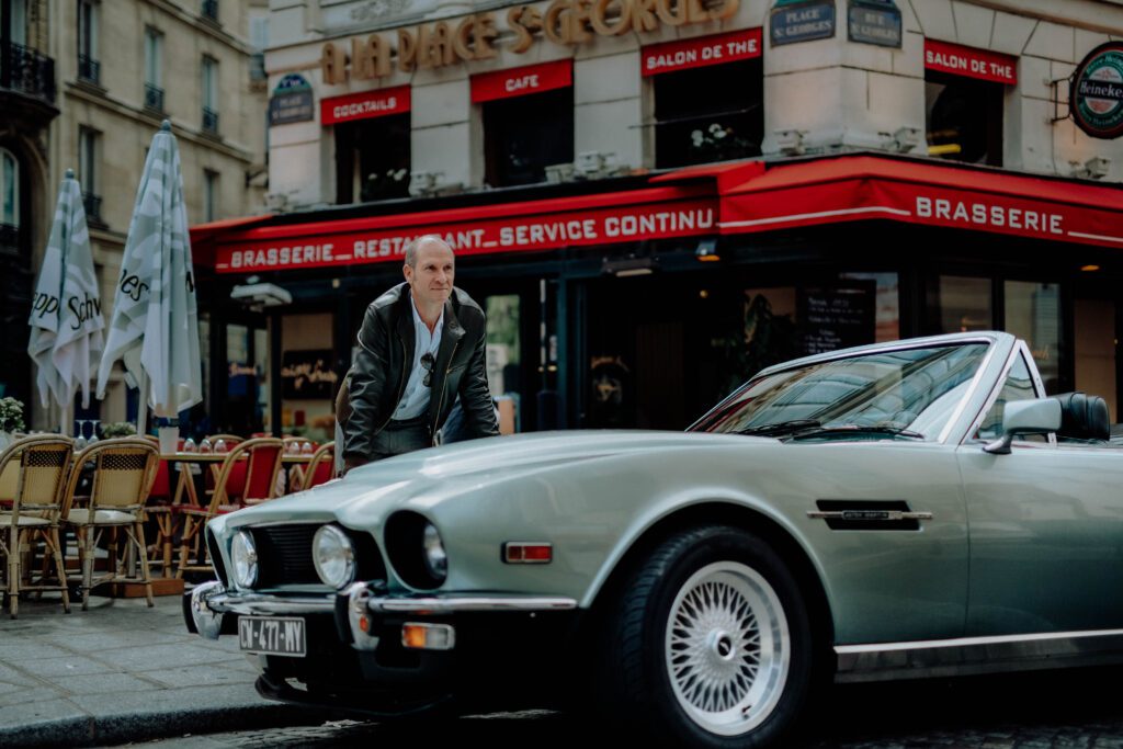 Tristan with vintage Aston Martin Tristan Auer standing next to his vintage Aston Martin in Paris during a lifestyle branding shoot for Wilson Associates.