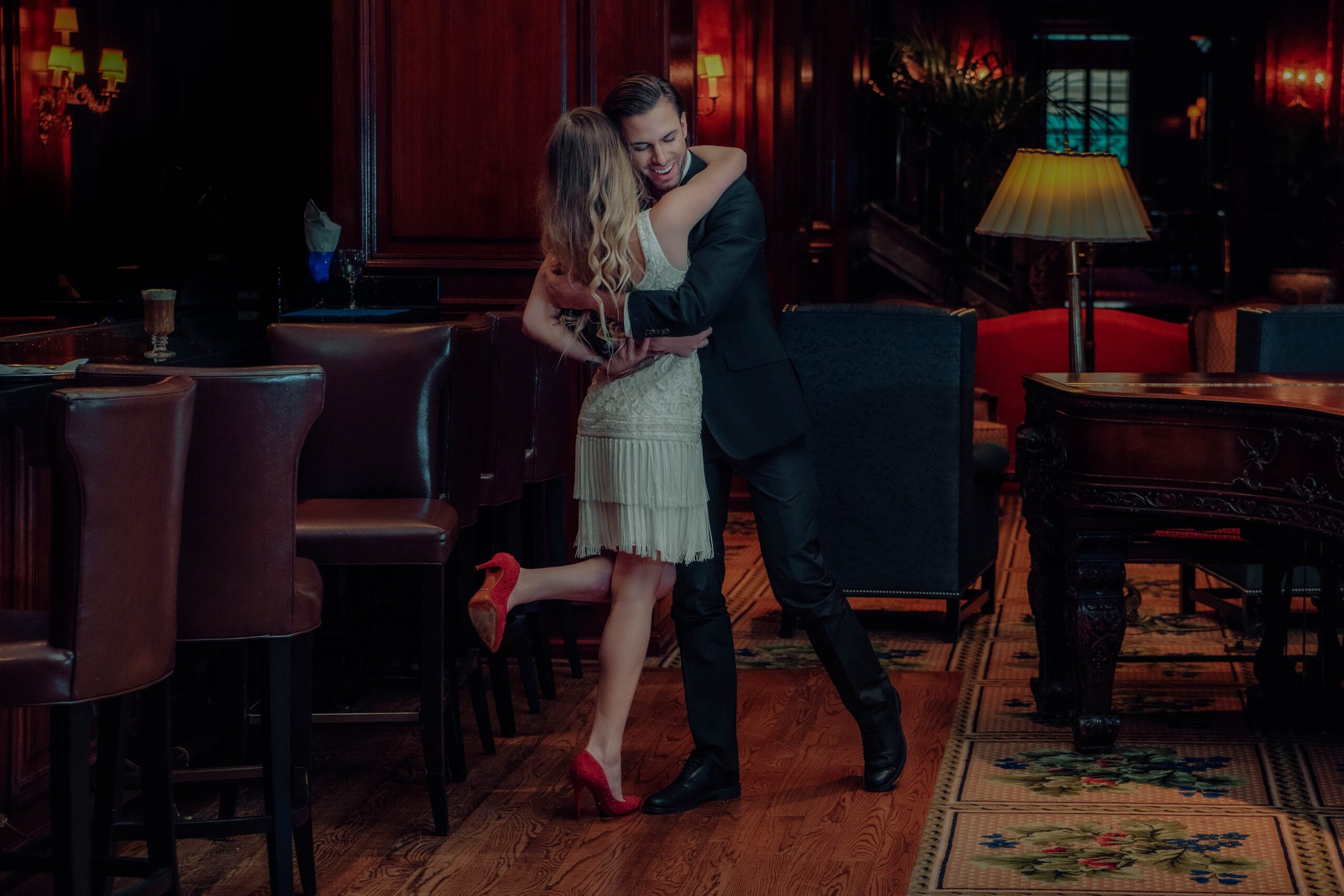 Couple hugging in vintage Gatsby-inspired outfits at the Adolphus Hotel in downtown Dallas